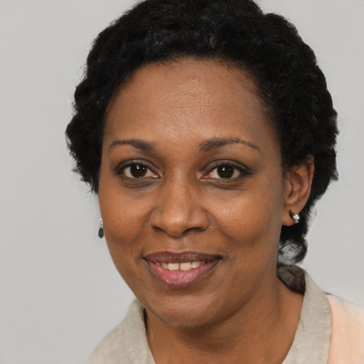 Joyful black adult female with short  black hair and brown eyes