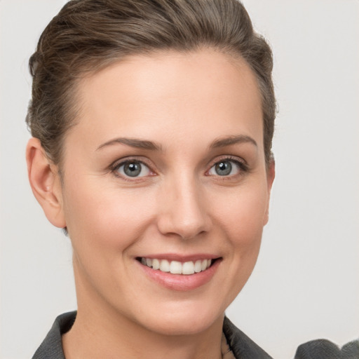 Joyful white young-adult female with short  brown hair and grey eyes