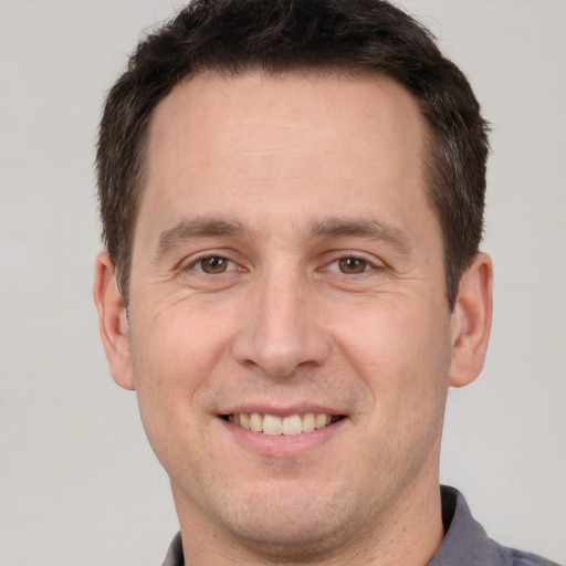 Joyful white adult male with short  brown hair and brown eyes