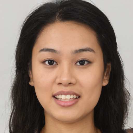 Joyful asian young-adult female with long  brown hair and brown eyes