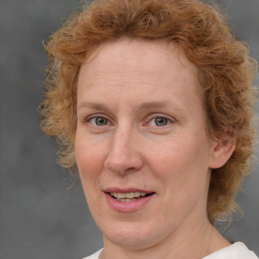 Joyful white adult female with short  brown hair and blue eyes