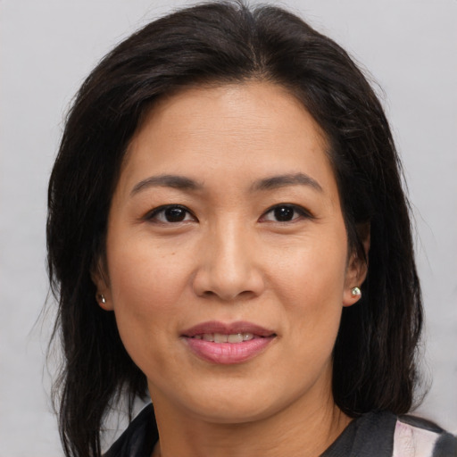 Joyful asian adult female with medium  brown hair and brown eyes