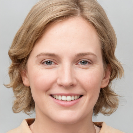 Joyful white young-adult female with medium  brown hair and blue eyes