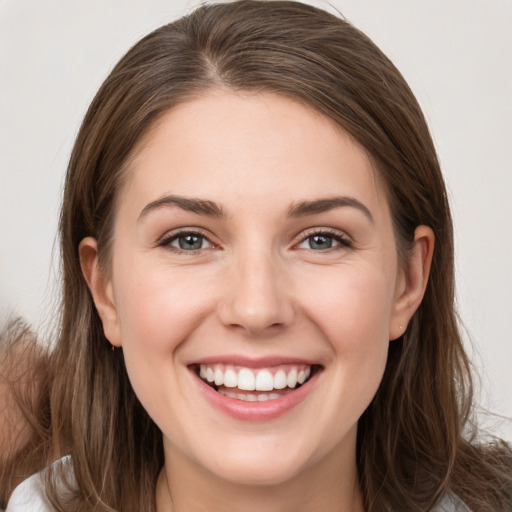 Joyful white young-adult female with long  brown hair and brown eyes