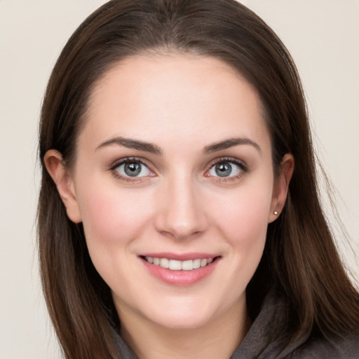 Joyful white young-adult female with long  brown hair and grey eyes