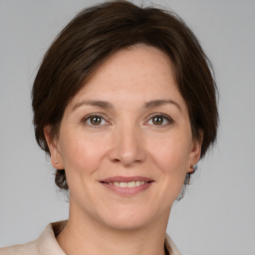 Joyful white adult female with medium  brown hair and grey eyes