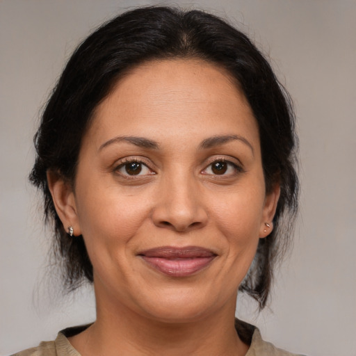 Joyful latino adult female with medium  brown hair and brown eyes