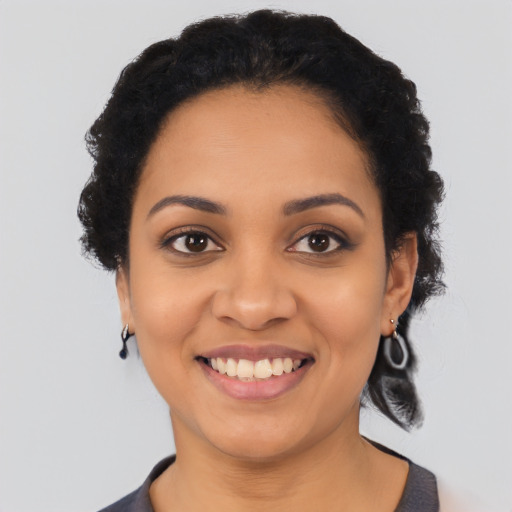 Joyful black young-adult female with short  black hair and brown eyes