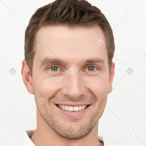 Joyful white young-adult male with short  brown hair and grey eyes