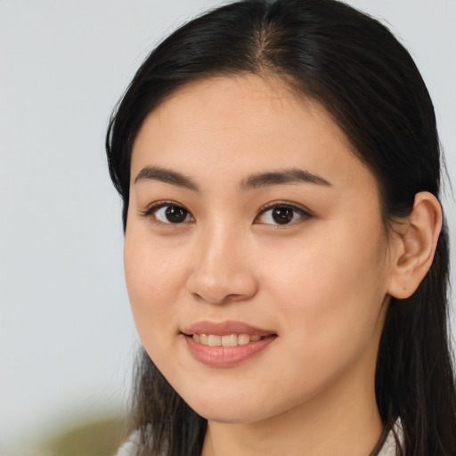 Joyful latino young-adult female with long  brown hair and brown eyes
