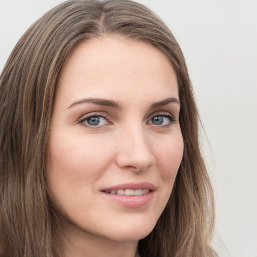 Joyful white young-adult female with long  brown hair and grey eyes