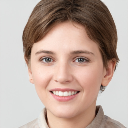 Joyful white young-adult female with short  brown hair and grey eyes