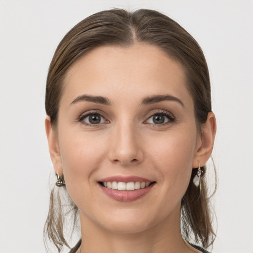 Joyful white young-adult female with medium  brown hair and grey eyes