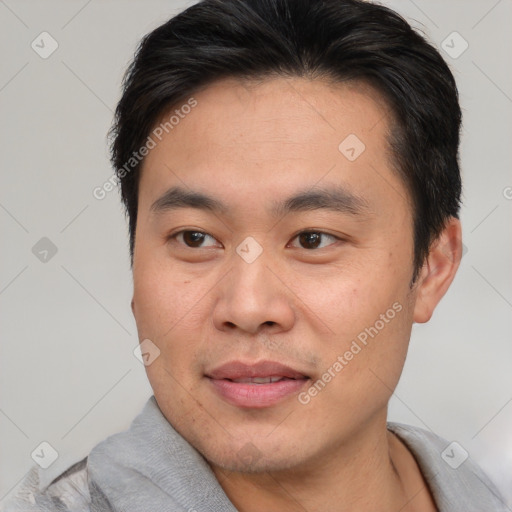 Joyful asian young-adult male with short  brown hair and brown eyes