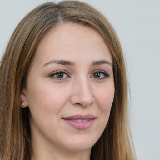 Joyful white young-adult female with long  brown hair and green eyes