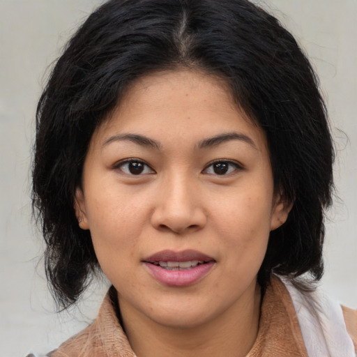 Joyful asian young-adult female with medium  brown hair and brown eyes