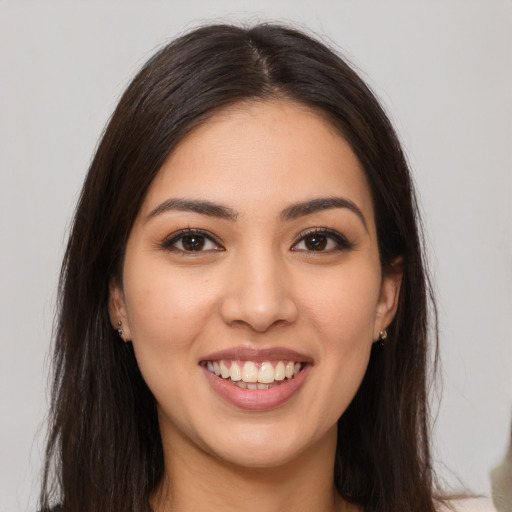 Joyful latino young-adult female with long  brown hair and brown eyes