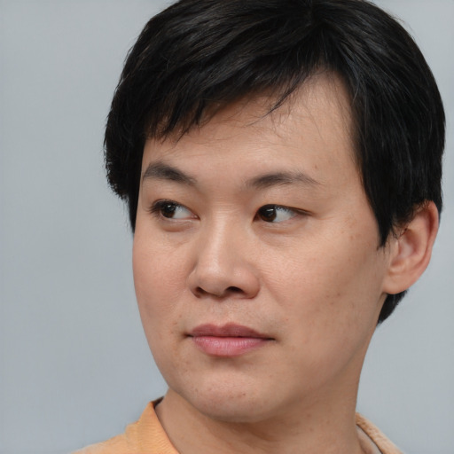 Joyful asian young-adult male with short  black hair and brown eyes