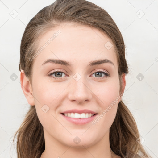 Joyful white young-adult female with medium  brown hair and grey eyes