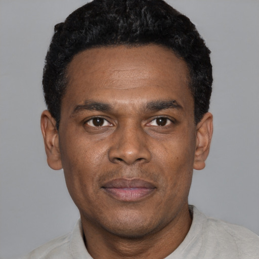 Joyful black young-adult male with short  black hair and brown eyes