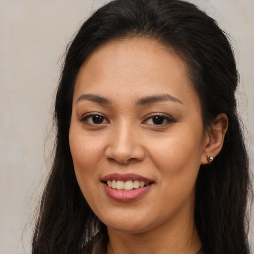 Joyful latino young-adult female with long  brown hair and brown eyes