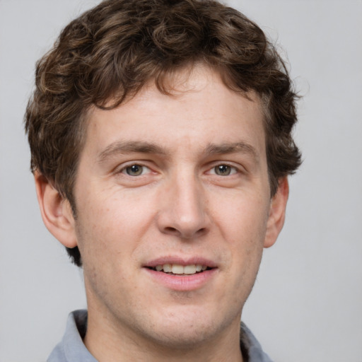 Joyful white adult male with short  brown hair and grey eyes