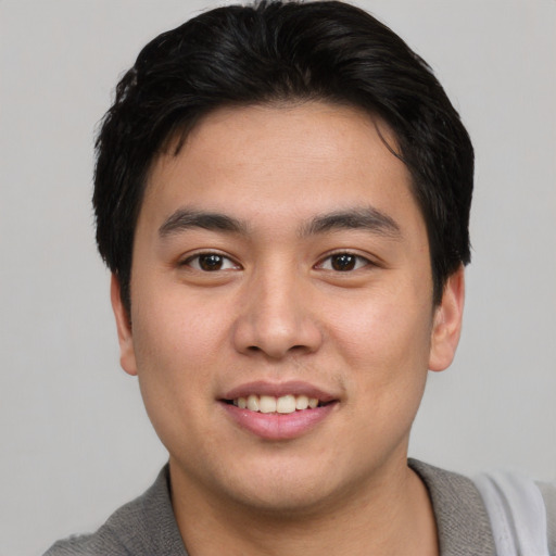 Joyful asian young-adult male with short  brown hair and brown eyes