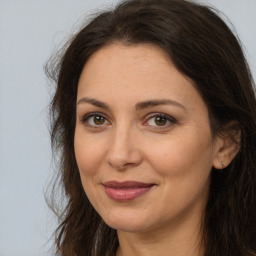 Joyful white adult female with long  brown hair and brown eyes