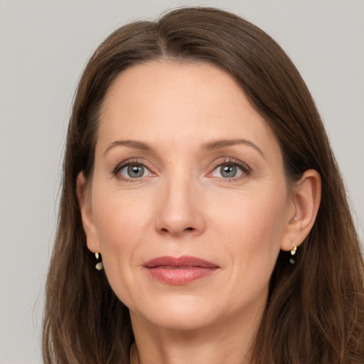 Joyful white adult female with long  brown hair and grey eyes