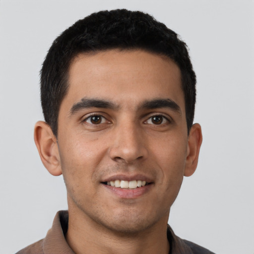 Joyful latino young-adult male with short  brown hair and brown eyes