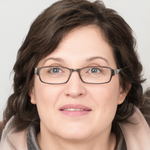 Joyful white adult female with medium  brown hair and green eyes