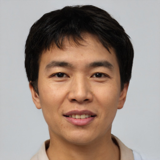 Joyful asian young-adult male with short  black hair and brown eyes
