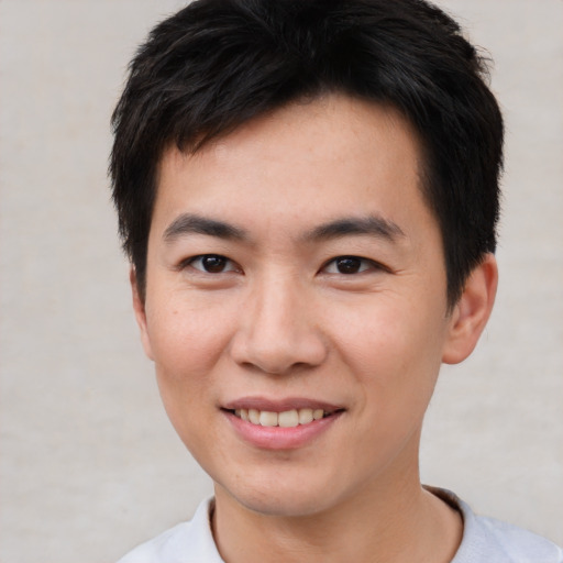 Joyful asian young-adult male with short  brown hair and brown eyes