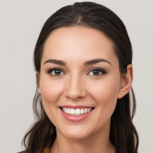 Joyful white young-adult female with long  brown hair and brown eyes