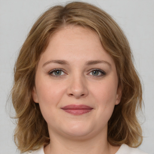 Joyful white young-adult female with medium  brown hair and green eyes