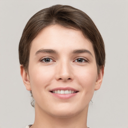 Joyful white young-adult female with short  brown hair and grey eyes