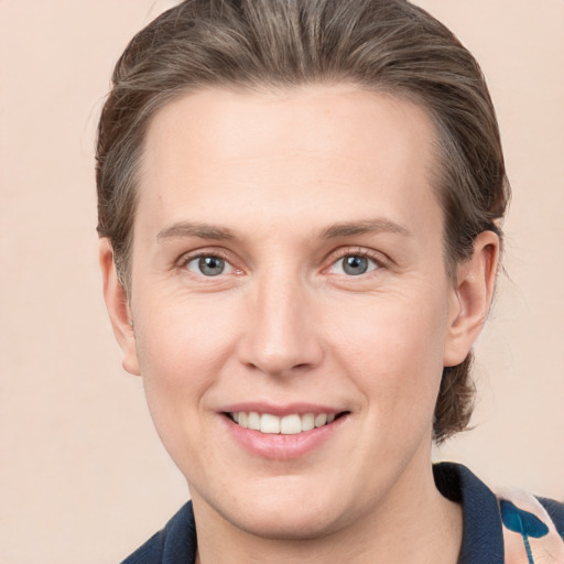 Joyful white young-adult female with medium  brown hair and grey eyes