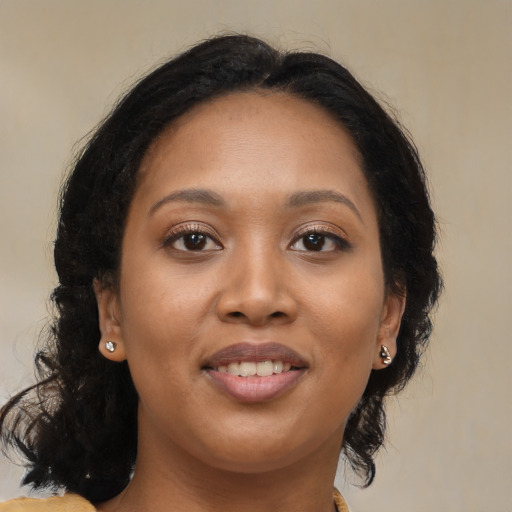 Joyful black young-adult female with long  brown hair and brown eyes