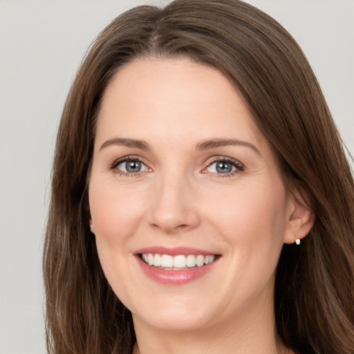 Joyful white young-adult female with long  brown hair and green eyes