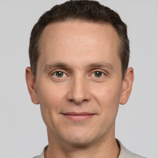 Joyful white adult male with short  brown hair and grey eyes