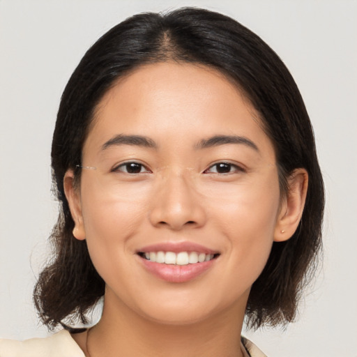 Joyful asian young-adult female with medium  brown hair and brown eyes