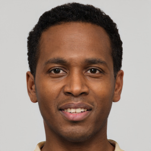 Joyful black young-adult male with short  black hair and brown eyes