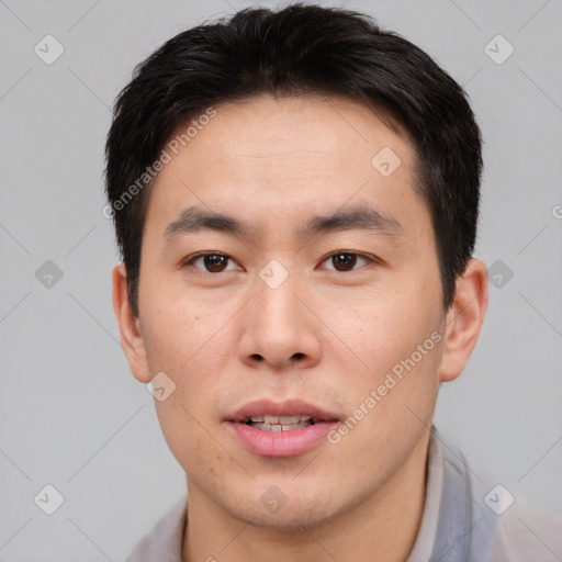 Joyful asian young-adult male with short  brown hair and brown eyes