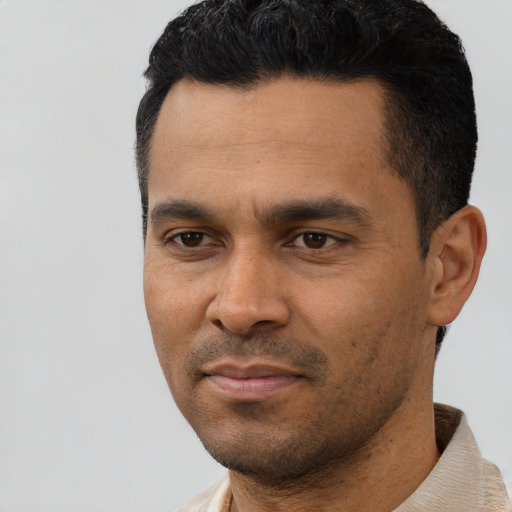 Joyful latino young-adult male with short  black hair and brown eyes
