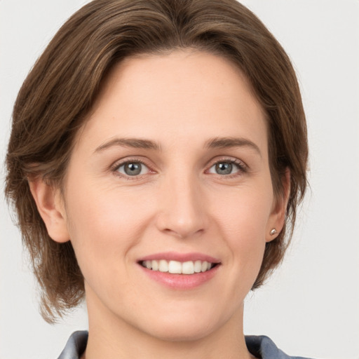 Joyful white young-adult female with medium  brown hair and grey eyes