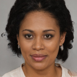 Joyful black adult female with medium  brown hair and brown eyes