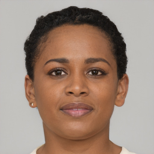 Joyful black young-adult female with short  brown hair and brown eyes