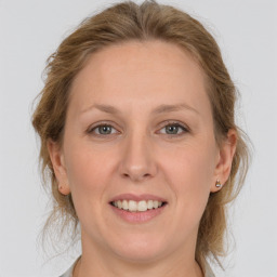 Joyful white adult female with medium  brown hair and grey eyes