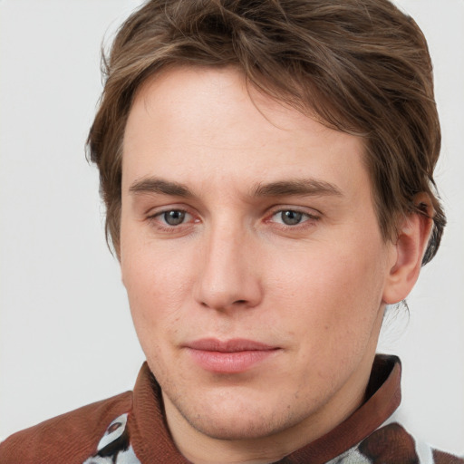 Joyful white young-adult male with short  brown hair and blue eyes