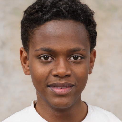 Joyful black child male with short  brown hair and brown eyes